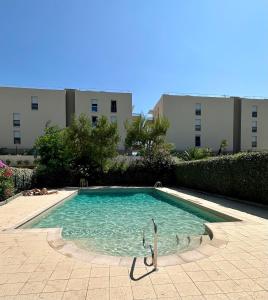 een zwembad in het midden van een gebouw bij Superbe appartement ensoleillé - Vue mer, Clim et Parking in Villeneuve-Loubet