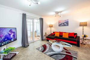 een woonkamer met een bank en een tafel bij Elite 2 Bedroom House in Chadwell Heath/ Romford with Free Wifi and Parking upto 4 guests in Goodmayes