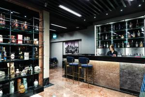 Eine Bar mit zwei Barhockern und Regalen voller Alkohol in der Unterkunft Dolamanco Hotel in Taipeh