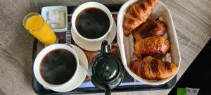 a tray with two cups of coffee and croissants and two cups of coffee at Zen in loft in Embry