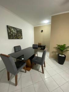 ein Esszimmer mit Tisch und Stühlen in der Unterkunft Apto Moderno com Churrasqueira Gourmet, apenas 150m da Praia in Praia Grande