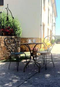 una mesa y dos sillas sentadas junto a una mesa en Apartamentos El Prado, en Valbona