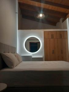 1 dormitorio con cama y espejo redondo en BELLΙSIMO3, en Parga