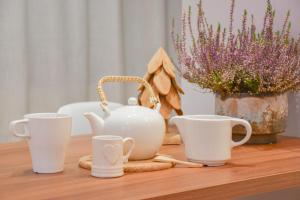 a table with three white cups and plants on it at Envalira Vacances - Sky in Pas de la Casa