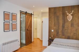 1 dormitorio con 1 cama y pared de madera en Sky - Studio au centre du Pas de la Case, rénové et charmant, en Pas de la Casa