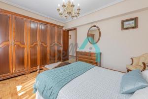 um quarto com uma cama, uma cómoda e um espelho em Vivienda vacacional Casa l'Capador em Nava