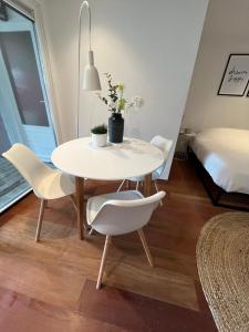 een witte tafel en stoelen in een kamer met een bed bij Studio J. in Egmond aan Zee
