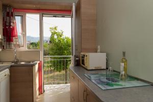 a kitchen with a counter and a window with a view at ΠΙΘΟΣ ΕΝΟΙΚΙΑΖΟΜΕΝΗ ΚΑΤΟΙΚΙΑ in Kalamata