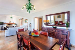 uma sala de jantar com uma mesa de madeira e uma sala de estar em Can Ferrando de Es Pontas em Cala Santanyi