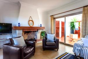 a living room with two chairs and a fireplace at Can Ferrando de Es Pontas in Cala Santanyi