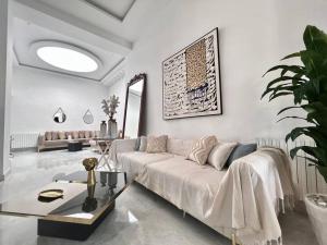 Sala de estar blanca con sofá y mesa en Villa du Bey à La Marsa, en La Marsa