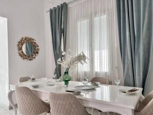 Villa du Bey à La Marsa في المرسى: غرفة طعام بيضاء مع طاولة بيضاء وكراسي