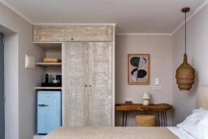 a bedroom with a wooden door and a desk at Selene Luxury Rooms in Armenistis