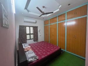 a bedroom with a bed and a ceiling fan at Vacation Rental Home in Kondapalle
