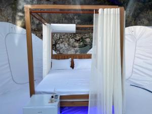 a bed in a room with a canopy at La Perle Palase in Palasë