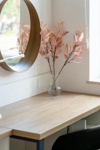 un vase de fleurs sur une table avec un miroir dans l'établissement RentPlanet - Studio Dyrekcyjna, à Wrocław