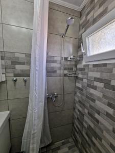 a shower with a shower curtain in a bathroom at Stella's Garden in Paleo Tsifliki