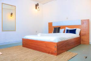 a bedroom with a large wooden bed with a mirror at Lakewalk Cabin in Naivasha