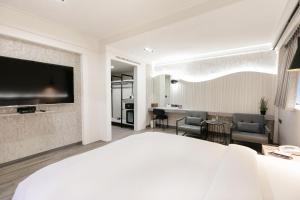 a hotel room with a bed and a television at Dolamanco Hotel in Taipei