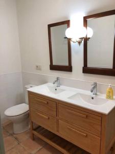 baño con lavabo, aseo y 2 espejos en Las Casas del Rincón- 7 dormitorios, en Villahermosa
