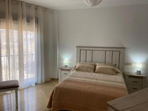 a bedroom with a bed and a large window at Alojamiento turístico Mar de Olivos in Baños de la Encina