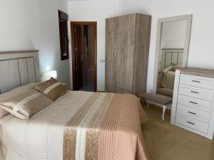 a bedroom with a bed and a dresser and a mirror at Alojamiento turístico Mar de Olivos in Baños de la Encina