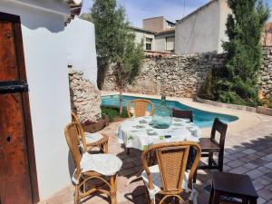 un patio con mesa y sillas junto a una piscina en Las Casas del Rincón- 7 dormitorios, en Villahermosa
