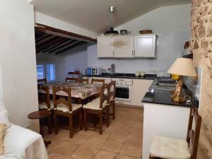 a kitchen with a table and chairs in a room at Las Casas del Rincón- 7 dormitorios in Villahermosa
