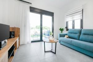 a living room with a blue couch and a table at Villa Irene in Polychrono