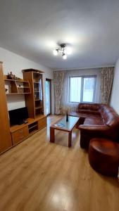 a living room with a leather couch and a coffee table at Апартамент Радост in Bansko