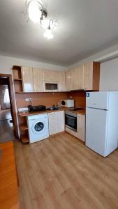 a kitchen with a white refrigerator and a dishwasher at Апартамент Радост in Bansko
