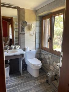 a bathroom with a toilet and a sink and a window at Farma Sarli in Monódhrion