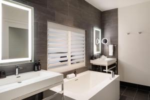 a bathroom with two sinks and a large mirror at HOTEL CERRO, Autograph Collection in San Luis Obispo