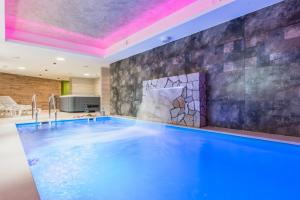 una piscina in una stanza con un muro in pietra di Hotel Tulipan a Tatranská Lomnica
