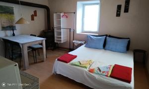 een slaapkamer met een bed met blauwe kussens en een tafel bij Granichar 2 Boards in Granichar