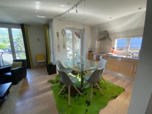 a kitchen and dining room with a glass table and chairs at Villa Meyronnes 3 chambres vue degagée montagnes in Barcelonnette