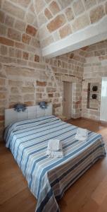 1 dormitorio con 1 cama grande en una pared de piedra en Brezza Marina, en Polignano a Mare