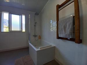 Un baño con bañera, lavabo y espejo. en L'Etreinte des Cimes, en Cilaos