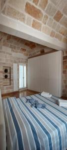 Cama grande en habitación con pared de ladrillo en Brezza Marina, en Polignano a Mare