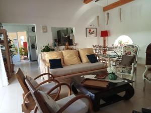 ein Wohnzimmer mit einem Sofa, Stühlen und einem Tisch in der Unterkunft Villa La Croisette in Sainte-Maxime