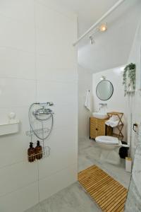 a white bathroom with a shower and a toilet at Robinson house T'n'T in Hvar