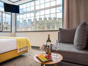 a hotel room with a bed and a table with a bottle of wine at Casa Senhoras Rainhas - Óbidos - by Unlock Hotels in Óbidos