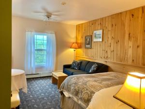 une chambre d'hôtel avec un lit et un canapé dans l'établissement Castle Rock Country Inn, à Ingonish Beach