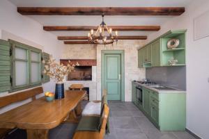 uma cozinha com armários verdes e uma mesa de madeira em Magnificent Luxury Villa Dominic em Privlaka