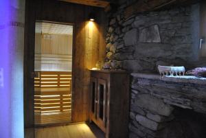 a room with a stone wall and a wooden door at Frantze, Le Rascard 1721 in Champoluc