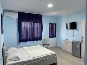 1 dormitorio con 1 cama y TV. en KOLKHETI JIBO Beach, en Grigoleti