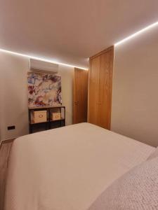 a bedroom with a white bed and a wooden cabinet at Acacias 841 A in Almancil