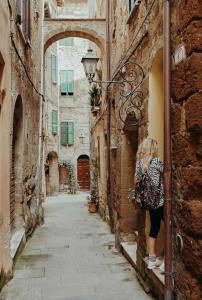 Una donna che guarda in un vicolo in una città vecchia di La Dolce Vita Fidardo a Pitigliano