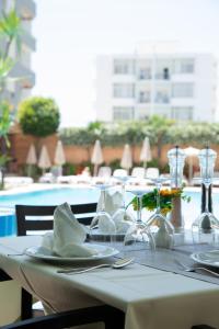 una mesa con copas de vino y servilletas encima en Hotel Dyrrah, en Durrës