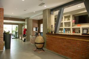 a bar in a building with a brick wall at Hotel Dyrrah in Durrës